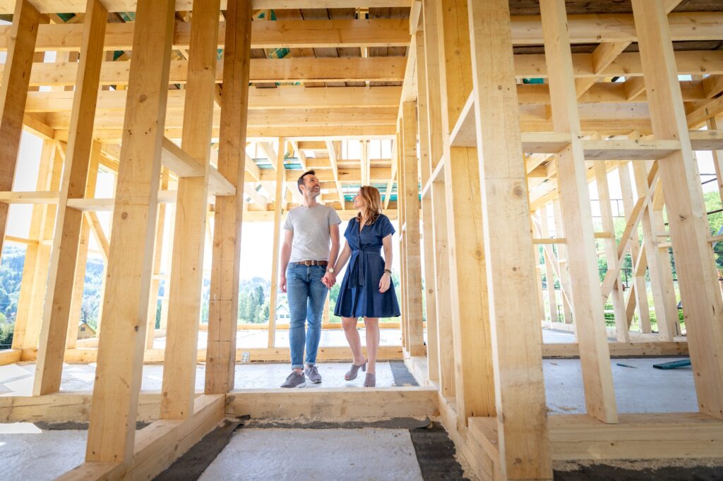 New home structure with couple walking through and admiring work